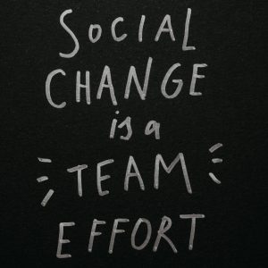 Inspirational quote 'Social Change is a Team Effort' on a black background, emphasizing collective action.